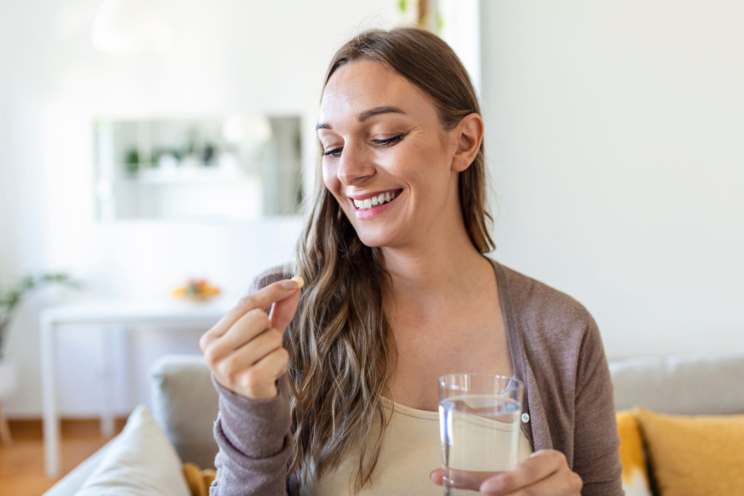 lady taking a pill with glass of water